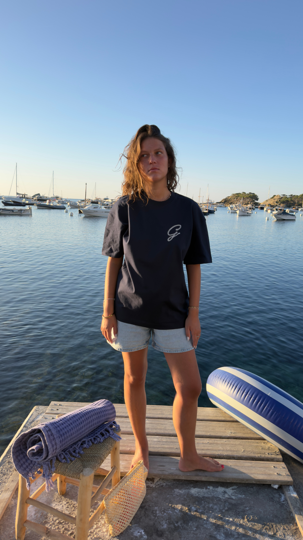 Femme portant le t-shirt Gamberge Club bleu marine inspiré par la Méditerranée.